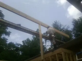 Carpenter setting a ridge beam over a new addition frame — Ice Dam Removal by Roofing Brothers in Bettsville