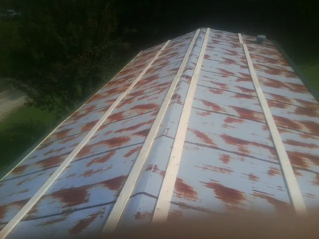 Rusted metal roof panels with new wood purlins before replacement — Storm Damage Roof Repair in Bettsville by Roofing Brothers