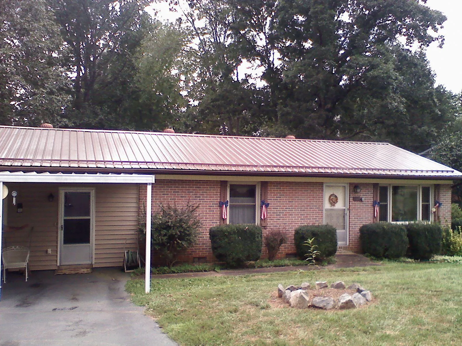 Bronze metal roof and carport on a brick ranch home — Roof Repair work by our crew in Bettsville
