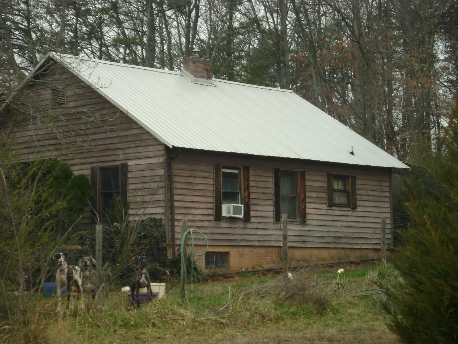 White metal roof on an old wood sided farmhouse, from a Metal Roof Installation job in Bettsville
